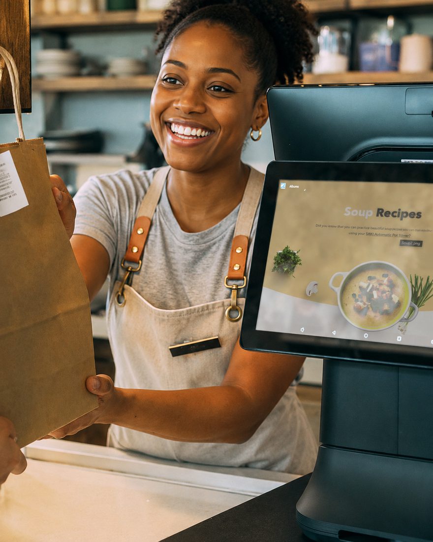 Store clerk handing a bag to a customer at the checkout counter