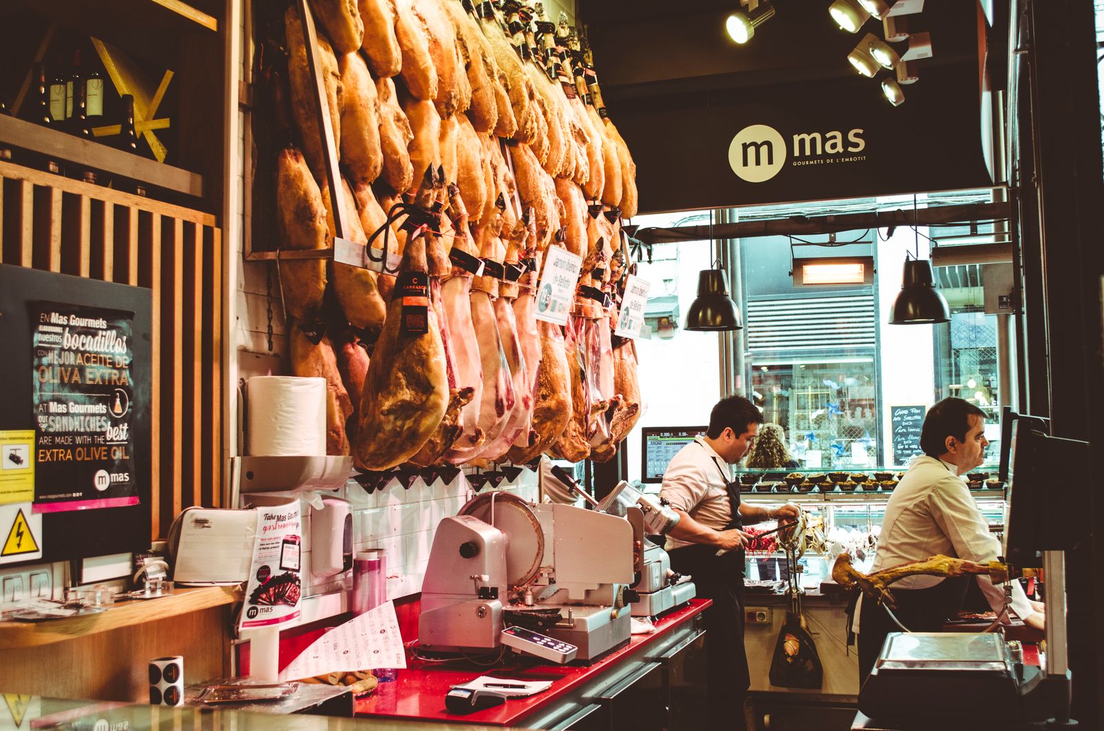 Busy neighborhood deli counter with staff serving customers